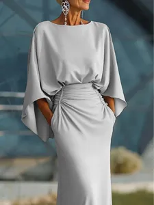 Detail shot of elegant boat neck evening gown featuring batwing sleeves and ruched high waist.