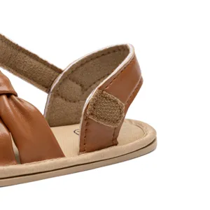 Detailed view of brown infant leather sandal showing soft strap and velcro closure.
