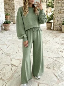 Grünes Loungewear Set Detail mit Pullover und Hose mit feiner Punktmuster Textur.