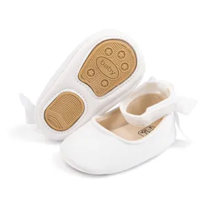 Detailed view of white velvet baby shoes sole texture and inner label, soft infant footwear.