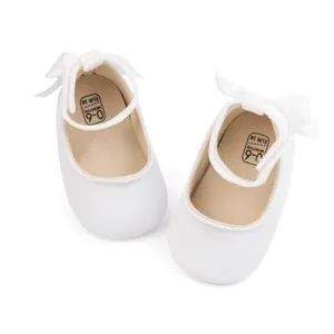 White velvet baby shoes detail, soft sole infant shoes with cute bow and 0-6m size mark.