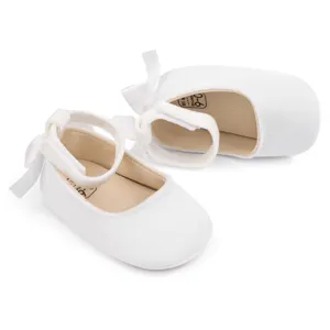 Detailed view of white velvet baby princess shoes with cute bow and ankle strap soft sole.