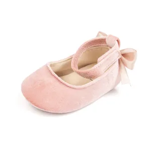 Detailed close-up of pink velvet baby princess shoes featuring a soft sole and cute bow.