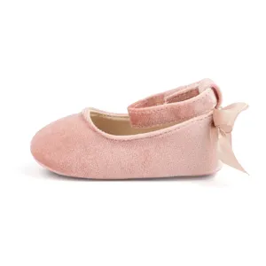 Pink velvet baby shoes detail view, soft sole infant crib shoes with cute bow and ankle strap.