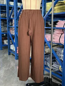 Detailed view of brown textured wide leg pants, high waist casual loose drape trousers.