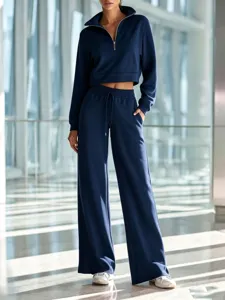 Detailed view of the stylish dark blue half-zip cropped sweatshirt and wide leg pants set.