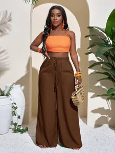 Solid textured wide-leg trousers paired with an orange crop top, showcasing beach casual style.