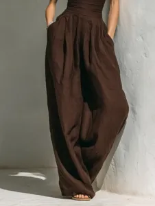 Brown linen sleeveless jumpsuit detail, high waist wide leg draped long pants style.