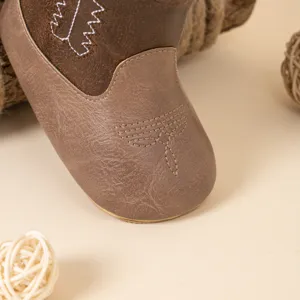 Botte cowboy en cuir PU pour bébé vue rapprochée avec belle broderie de surpiqûre marron.