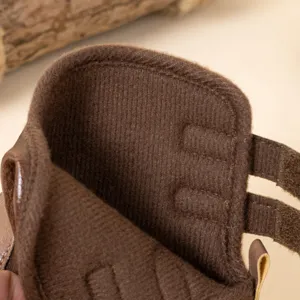 Gros plan détaillé de la doublure douce et de la sangle velcro de la bottine pour bébé.