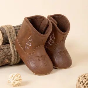 Gros plan de bottes de cowboy pour bébé marron avec broderie, cuir PU et doublure peluche.