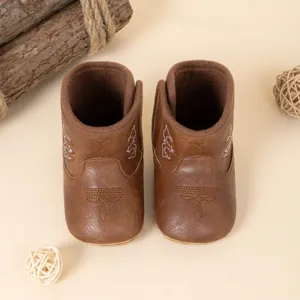 Bottes de cowboy pour bébé en cuir PU marron avec détails de broderie délicats en gros plan.