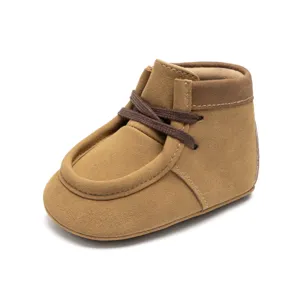 Nahaufnahme der braunen Babyschuhe aus Wildleder mit weicher Sohle und feinen Details.