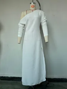 White long sleeve knit dress detail showing asymmetric neckline, side slit and delicate fabric texture.