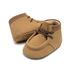 Nahaufnahme von braunen Lauflernschuhen mit weicher Sohle und hübschen Schnürsenkeln für Babys.