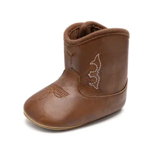 Gros plan sur les détails de la botte de cow-boy marron pour bébé avec coutures blanches.