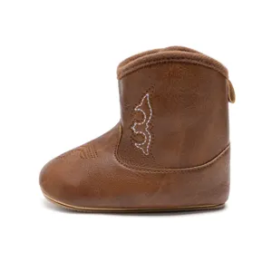 Gros plan détaillé de la botte de cow-boy en cuir PU pour bébé avec doublure en fausse fourrure.