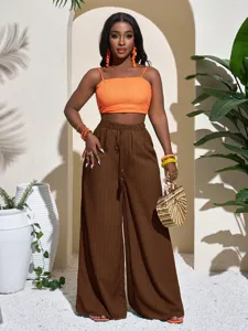 Casual resort style high waist textured wide leg trousers and crop top outfit detail shot.