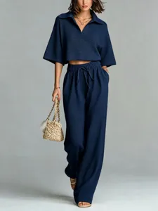 Navy blue knit set detail, stylish polo collar top and matching high-waisted wide-leg trousers.