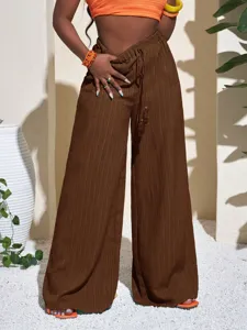 Detail view of solid color textured wide-leg trousers, high waist with adjustable drawstring.