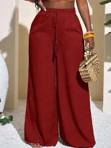 Textured wide-leg pants detail showing high waist, drawstring and lightweight fabric design.