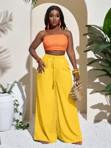 Close-up shot of the textured wide-leg trousers and cropped top in a resort scene setting.