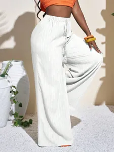 Detailed view of women's white textured high-waist wide-leg pants with casual drawstring.
