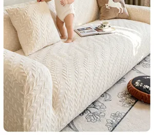Textured beige stretch sofa slipcover detail showing leaf embossed pattern in living room