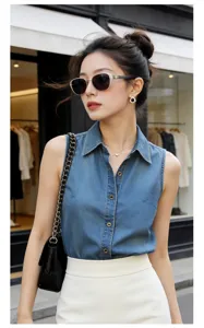 Sleeveless denim shirt detail featuring classic lapel collar and metal button closure.