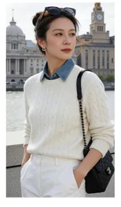 Detailed view of women's white cable knit sweater layered with stylish denim fake collar.