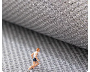 Close-up detail of grey cooling rattan sofa mat texture, breathable mesh fabric for summer.