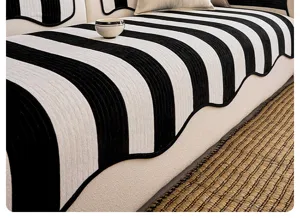 Dettaglio cuscino divano in ciniglia con design a righe bianche e nere moderne.