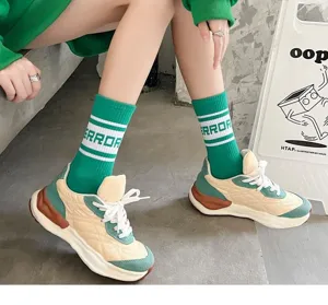 Green mid-tube fashion socks with white stripes and unique print detail, perfect streetwear.