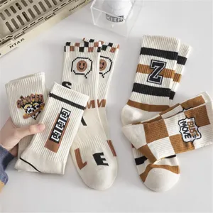 Chaussettes mi-hautes tendance pour hommes en coton avec motifs carreaux et lettres stylés.