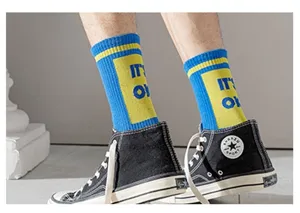 Close up of blue and yellow cotton mid-tube sports socks with IT'S OK letter design.
