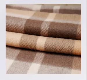 Close-up detail of soft brown and camel plaid wool scarf fabric texture showing warmth.