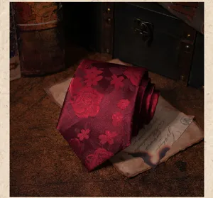 Detalle de corbata vintage rojo oscuro con elegante patrón floral jacquard para traje.