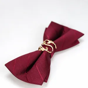 Farfallina bordeaux con anello foglia d'oro, elegante accessorio formale da sposo.