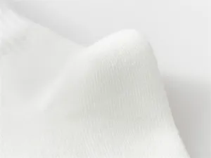 Detailed close-up of white cotton knit sock texture, soft and breathable fabric quality.