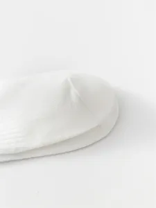 Close-up detail of white cotton socks, showing soft fabric and neat toe seam construction.