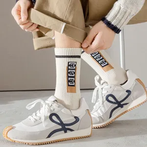 Chaussettes mi-hautes homme en coton pur associées à des chaussures de sport stylées.