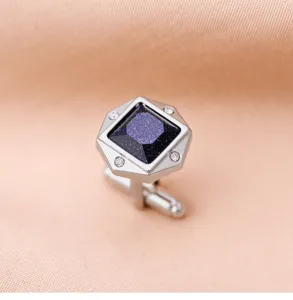 Gros plan détaillé de boutons de manchette homme luxueux avec grès bleu et cristaux brillants.