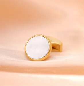 Vue détaillée de boutons de manchette élégants pour hommes avec bord doré et insert blanc nacré.