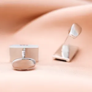 Boutons de manchette métalliques élégants pour hommes, parfaits pour chemises habillées.