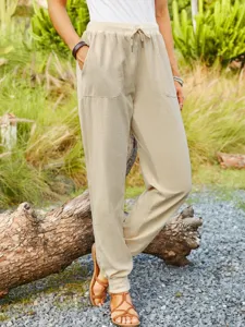 Detailed shot of women's casual cotton linen trousers with elastic drawstring and pockets.