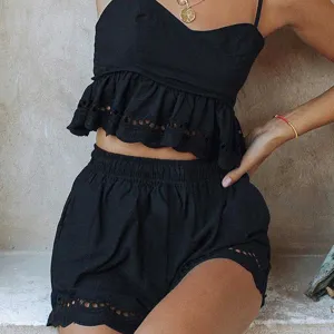 Gros plan du haut camisole noir et du short avec de délicats volants en dentelle ajourée.