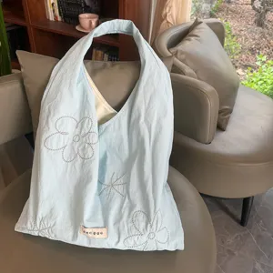 Lichtblauwe nylon totebag met geborduurde bloemen, zoete stijl schoudervesttas detailweergave.