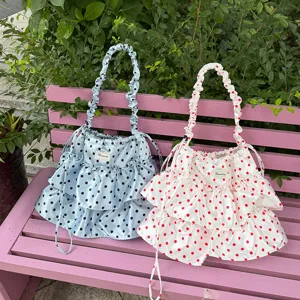 Bolso de cordón de satén con lunares y volantes, detalle de bolso estilo dulce en banco exterior