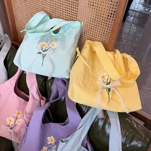 Zoete nylon schoudertas met schattige bloemborduursel en delicate kanten strikken.