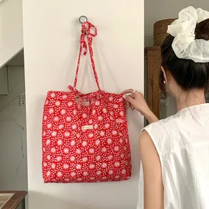 Borsa in tessuto rosso con stampa floreale e graziosi lacci a fiocco appesa dettaglio.